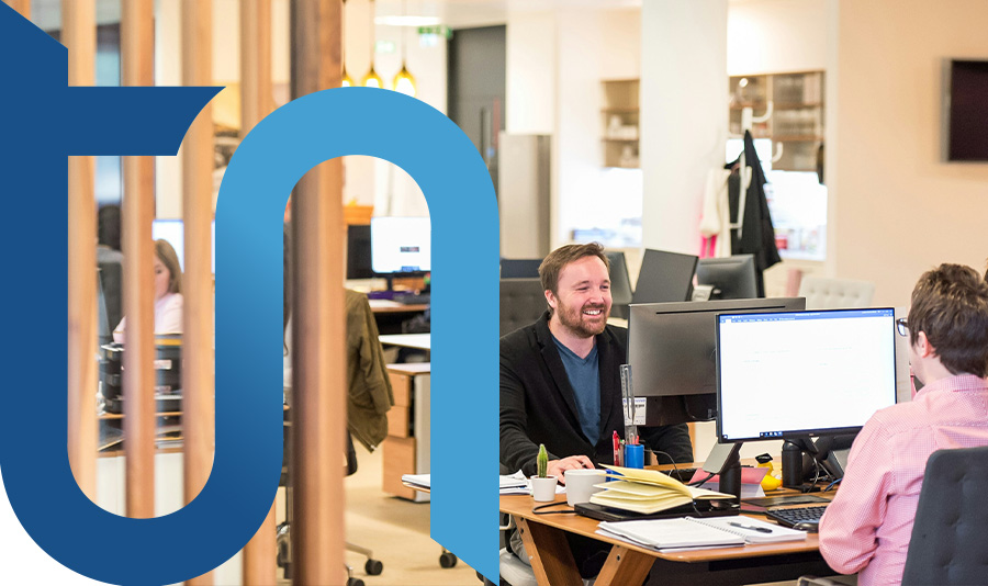 Acquistare un numero voip per l'azienda significa incrementare la propria digitalizzazione e rendere i collaboratori più indipendenti e sereni come si vede da questa foto di due persone davanti al pc in modo sorridente e tranquillo mentre lavorano